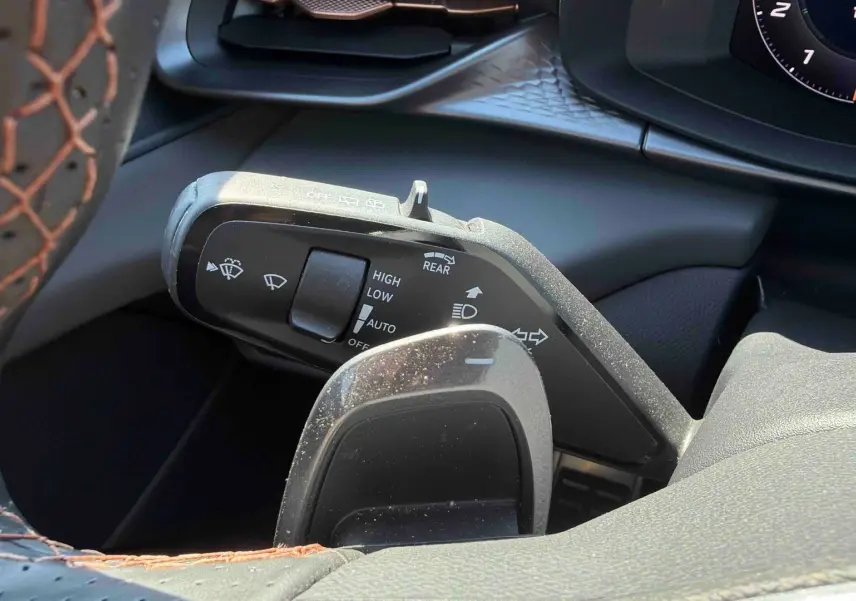Gros plan sur la manette de commandes au volant cuir noir avec surpiqûres cuivrées du CUPRA Terramar 2025.