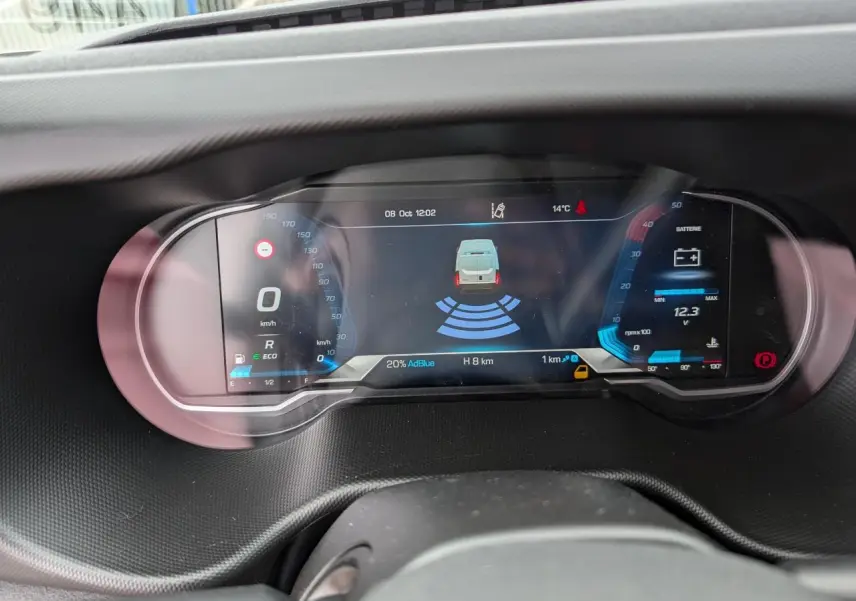 Tableau de bord numérique du Iveco Daily 35S16 avec affichage de la batterie, vitesse et assistance au stationnement.