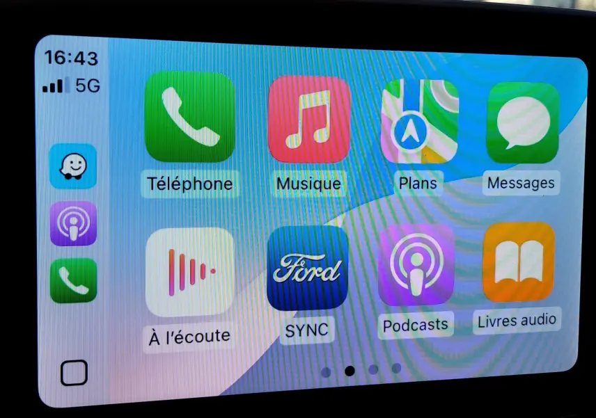 Écran tactile intérieur du Ford Puma 2020 affichant les applications Apple CarPlay avec interface colorée et claire.