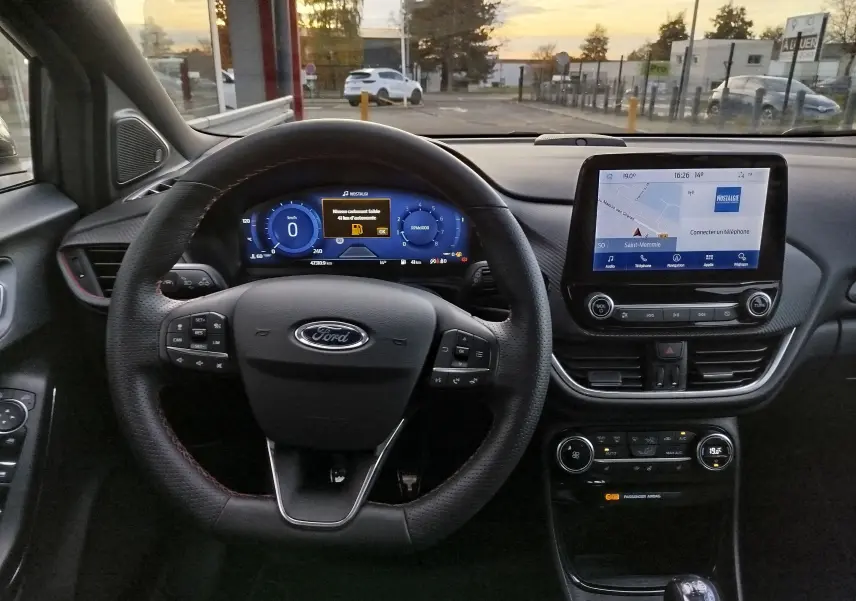 Vue intérieure du tableau de bord et volant du Ford Puma 1.0 EcoBoost, avec écran tactile et commandes au volant.