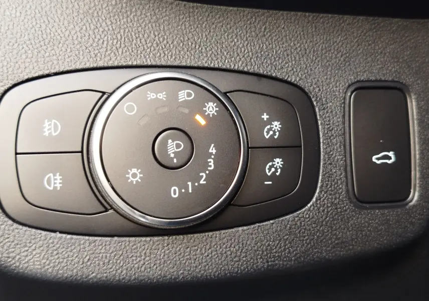 Gros plan sur le sélecteur d'éclairage noir et les commandes de réglage de luminosité du Ford Puma gris métallisé 2020.