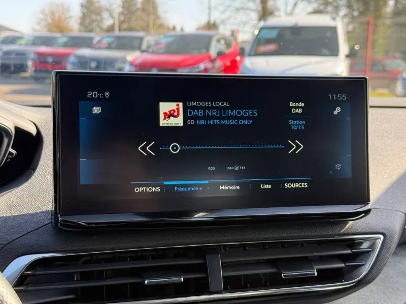 Écran central tactile du Peugeot 3008 2024 affichant la radio DAB NRJ, avec tableau de bord noir en arrière-plan.