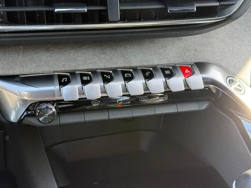 Gros plan sur la rangée de boutons métalliques du tableau de bord du Peugeot 3008 GT 2024 en Gris Platinium.