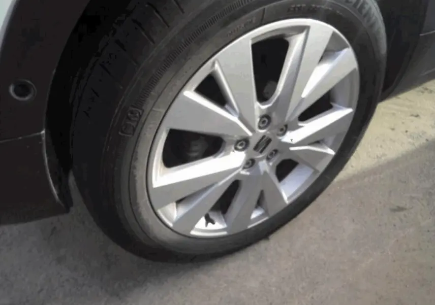 Gros plan sur la jante alliage 17'' « Dynamic » d’un SEAT Arona blanc Nevada, avec pneu visible sur sol gris.