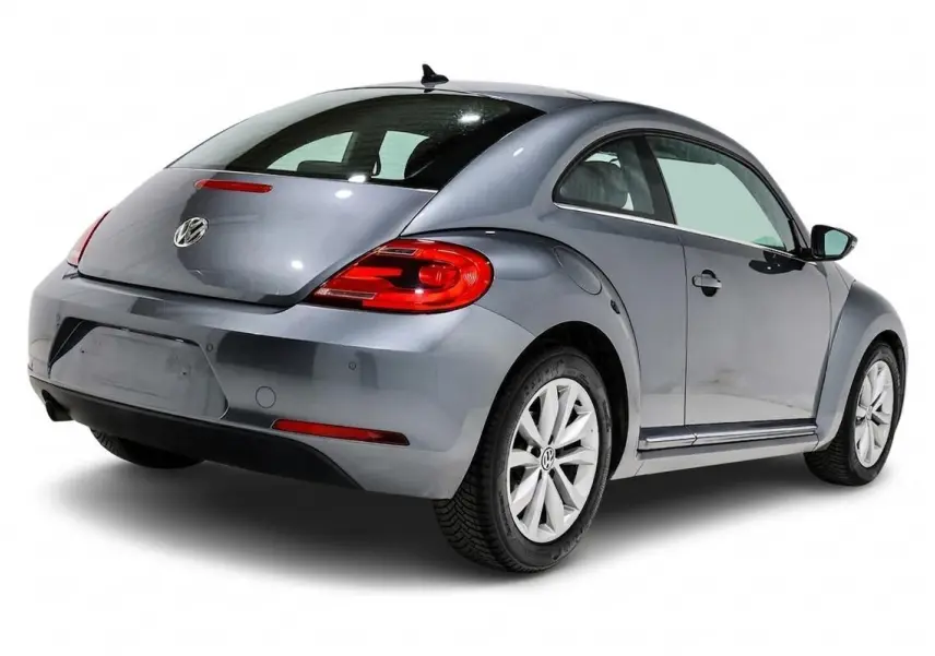 Vue 3/4 arrière droite d'une Volkswagen Coccinelle gris métallisé avec feux arrière rouges et jantes alliage.