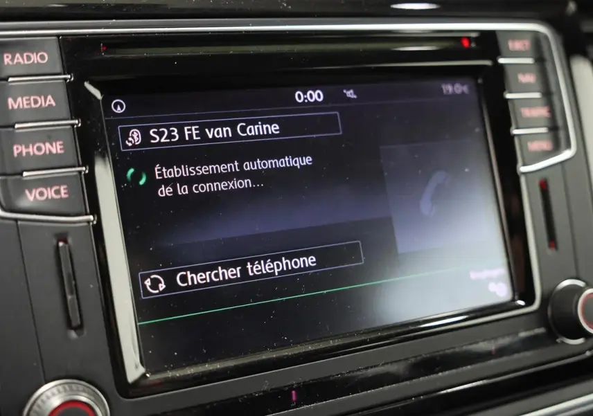Écran tactile du système GPS et multimédia de la Volkswagen Coccinelle 2016 avec commandes latérales visibles.