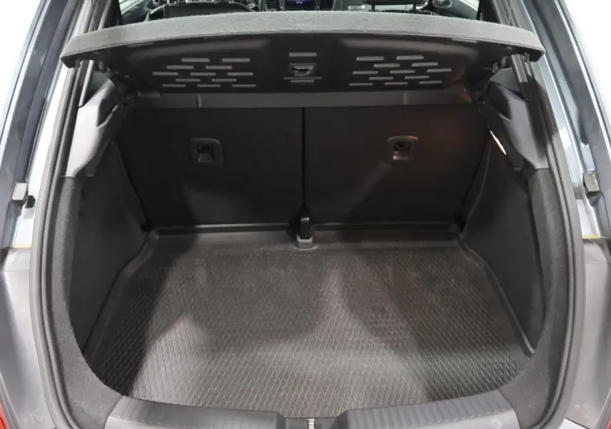 Coffre ouvert vu de l'arrière d'une Volkswagen Coccinelle gris 2016, montrant l'espace de chargement vide.