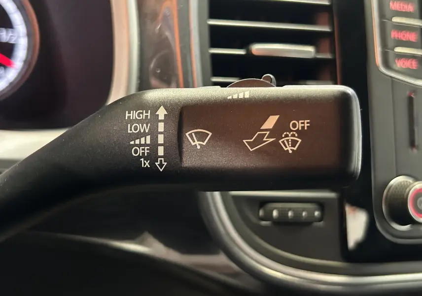 Gros plan sur la manette de commande des essuie-glaces dans l’habitacle gris du Volkswagen Coccinelle 2016.