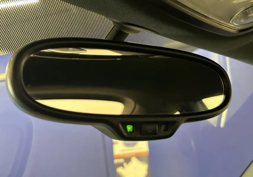 Rétroviseur intérieur noir de Volkswagen Coccinelle 2016 avec témoin vert d'activation, vue rapprochée depuis l'habitacle.