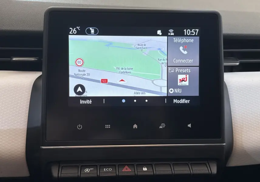 Écran tactile central affichant la navigation et les options multimédias dans le tableau de bord d'une Renault Clio blanche.