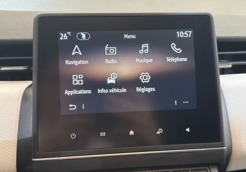 Écran tactile central affichant le menu multimédia de la Renault Clio blanche, vue de face en intérieur.