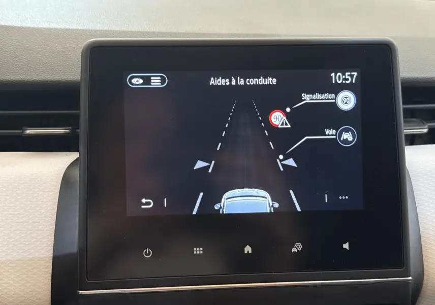Écran tactile central affichant les aides à la conduite sur Renault Clio blanc, vue intérieure tableau de bord.