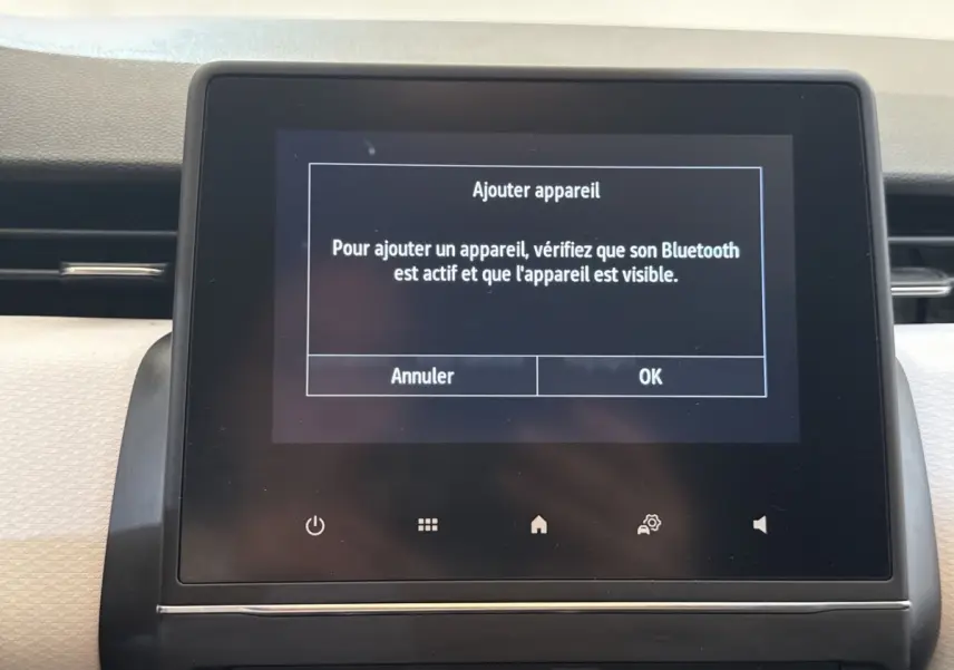 Écran tactile central du tableau de bord de la Renault Clio blanc, affichant un message Bluetooth.