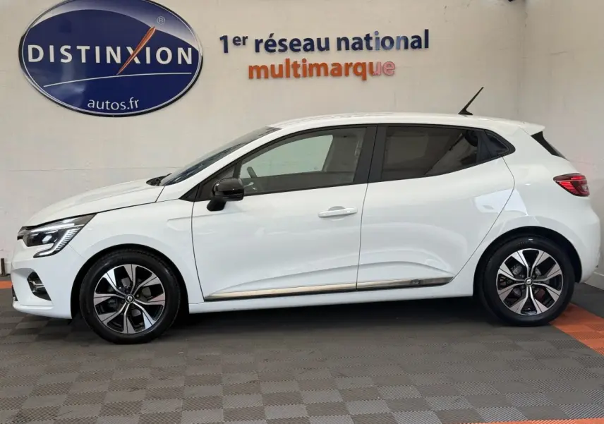 Profil droit d'une Renault Clio Evolution TCe 100 GPL blanche, avec jantes alliage bicolores et rétroviseurs noirs.