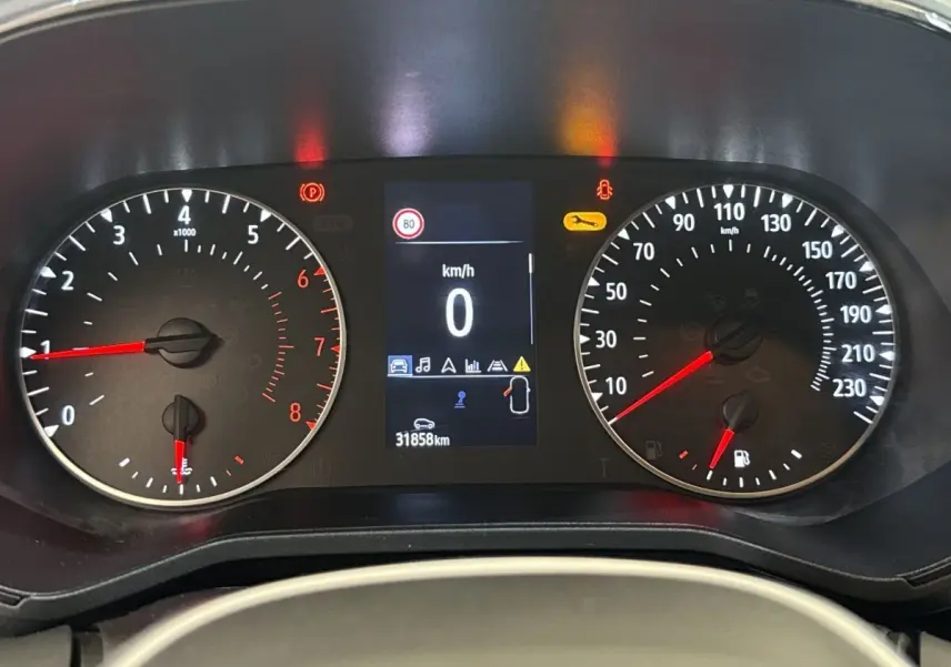 Tableau de bord de Renault Clio blanc 2023, affichage digital au centre avec compte-tours et vitesse à zéro.