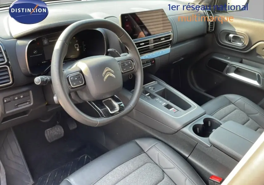 Intérieur avant du Citroën C5 Aircross 2025, vue côté conducteur, tableau de bord et console centrale noirs.
