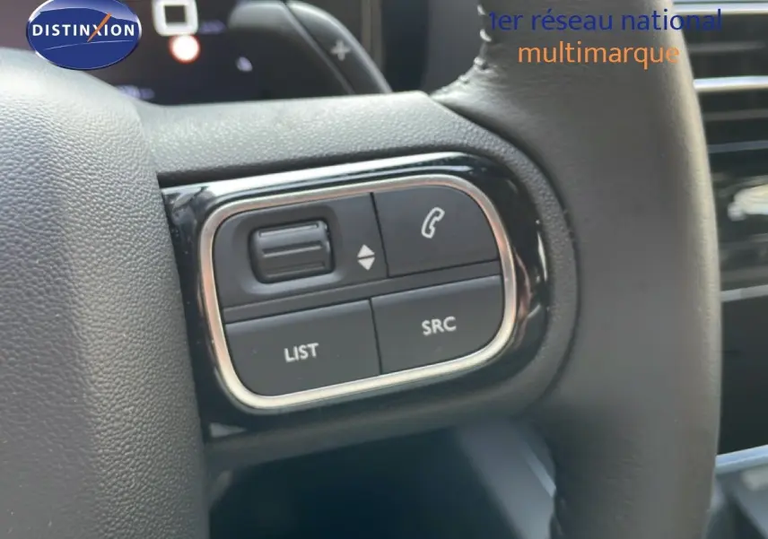 Gros plan sur les commandes gauche du volant du Citroën C5 Aircross 2025, finition noire avec boutons fonction téléphonie et audio.