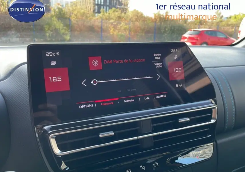 Vue intérieure du tableau de bord du Citroën C5 Aircross 2025, écran tactile affichant la radio DAB, finition en cuir noir avec surpiqûres bleues.