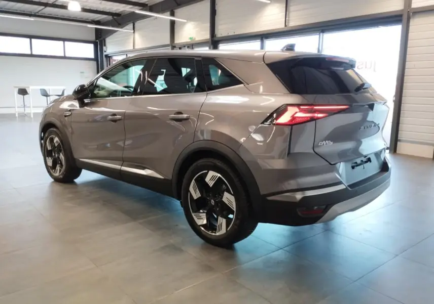 Vue 3/4 arrière droite du Renault SYMBIOZ gris Cassiopée avec jantes 18 pouces et feux arrière LED allumés.