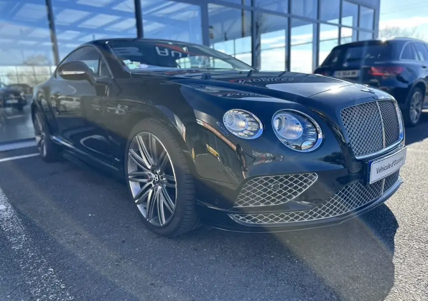 Bentley Continental GT Speed noire vue en 3/4 avant droit, mettant en valeur sa calandre et ses phares ronds distinctifs.