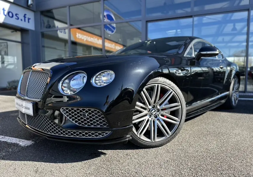 Bentley Continental GT Speed noire vue 3/4 avant droit, avec calandre chromée et jantes alliage distinctives.