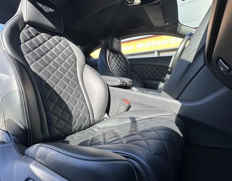Intérieur noir de la Bentley Continental GT Speed 2015, vue rapprochée des sièges avant en cuir matelassé avec logo Bentley brodé.