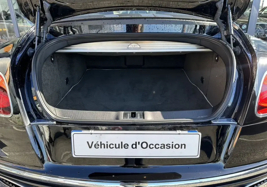 Coffre ouvert vu de l'arrière d'une Bentley Continental GT Speed noire de 2015 avec finition intérieure soignée.