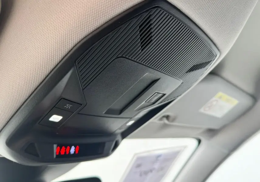 Vue en gros plan du plafonnier noir et beige avec éclairage intérieur de la Peugeot 308 SW blanche 2024