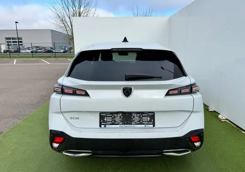 Vue arrière d'une Peugeot 308 SW blanche Okenite avec feux LED distinctifs et double sortie d'échappement chromée.