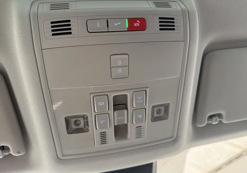 Vue en gros plan du panneau de commandes au plafond du SEAT Ateca gris clair 2023, avec boutons SOS et éclairage.