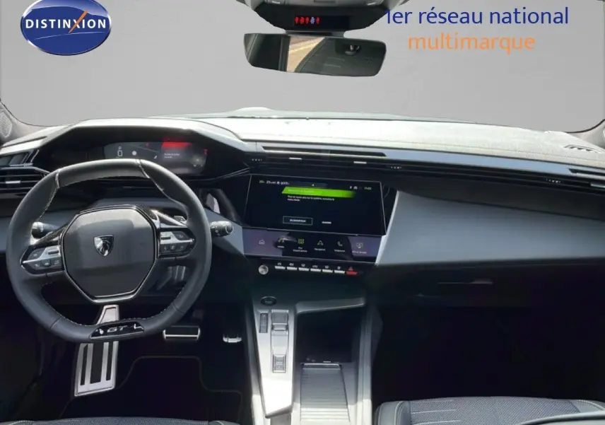 Vue intérieure avant du tableau de bord et volant cuir noir du Peugeot 308 1.2 Hybrid 145ch GT, avec écran tactile central.