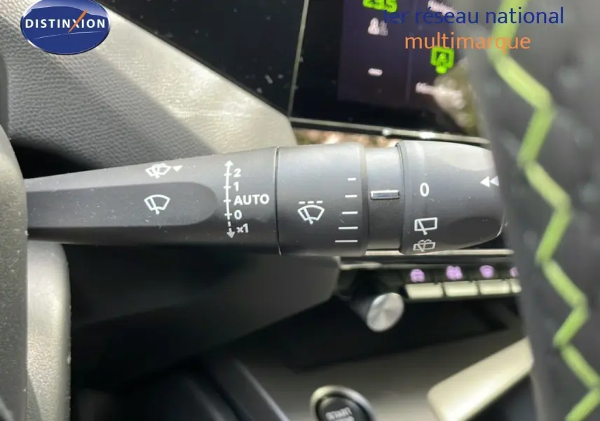 Gros plan sur la commande d’essuie-glace à gauche du volant d’une Peugeot 308 gris Artense, intérieur noir.