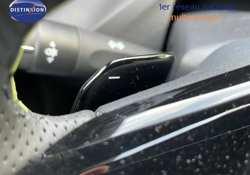 Gros plan sur la palette de changement de vitesse noire côté droit du volant perforé dans une Peugeot 308 gris Artense.
