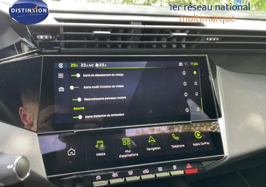 Vue rapprochée de l’écran tactile central du tableau de bord d’une Peugeot 308 gris Artense, affichant les options de sécurité et multimédia.