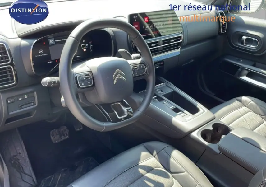 Vue intérieure côté conducteur du Citroën C5 Aircross gris platinium, avec tableau de bord numérique et sellerie cuir noire.