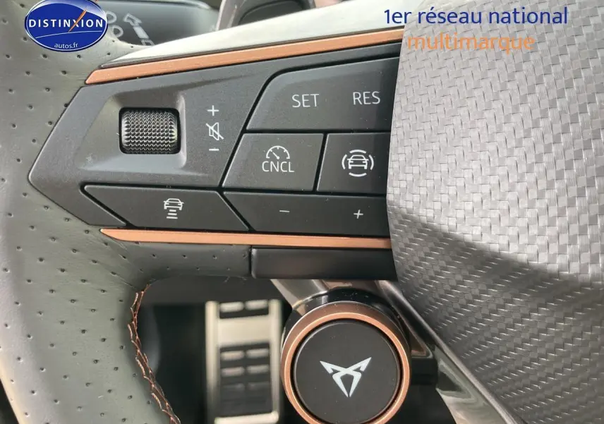 Gros plan sur les commandes multifonctions du volant cuir perforé avec logo CUPRA et surpiqûres cuivre.