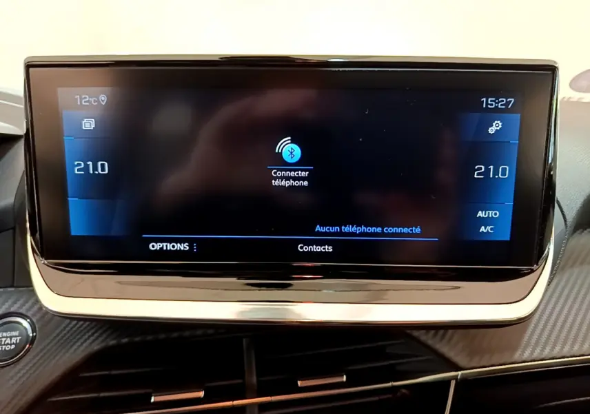 Écran tactile central affichant la connexion Bluetooth dans l'habitacle d'une Peugeot 208 gris clair, version Allure Business.