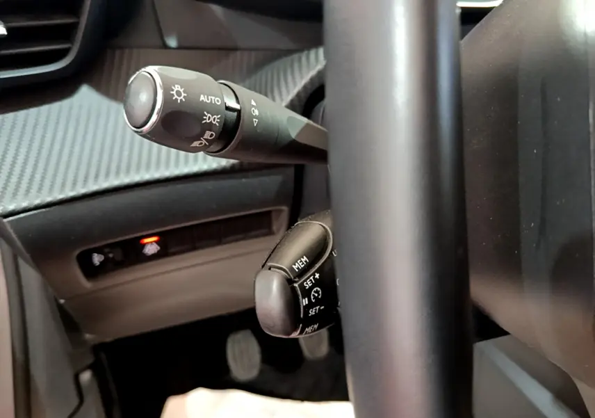 Gros plan sur les commandes au volant noir de la Peugeot 208 PureTech 100 S&S Allure Business 2020.