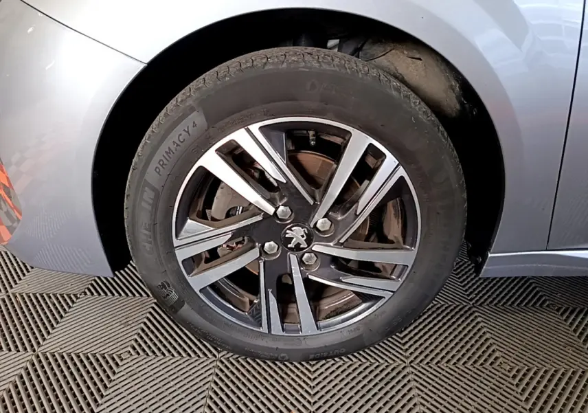 Gros plan sur la roue avant gauche gris clair d'une Peugeot 208 PureTech 100 S&S Allure Business 2020.