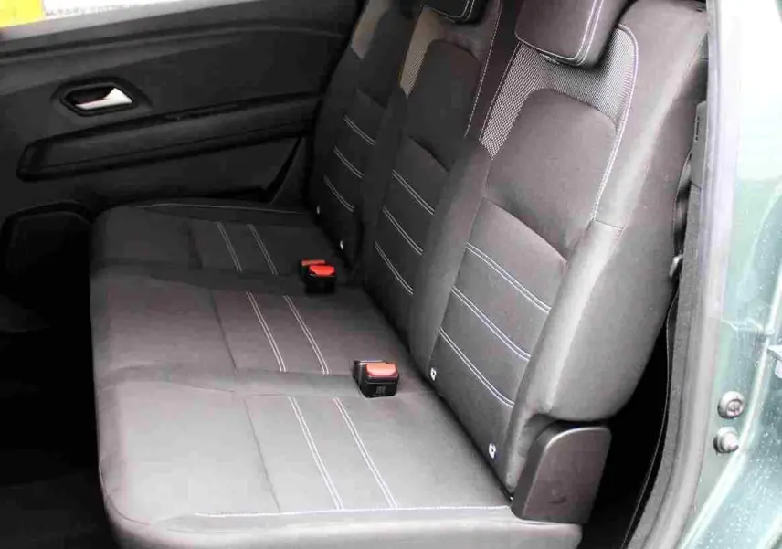 Vue intérieure côté droit des sièges arrière en tissu noir avec surpiqûres bleues du Dacia Jogger vert cèdre métal 2025.