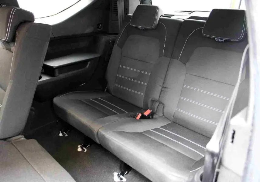 Vue intérieure sur la banquette arrière en tissu noir avec surpiqûres blanches du Dacia Jogger 2025.