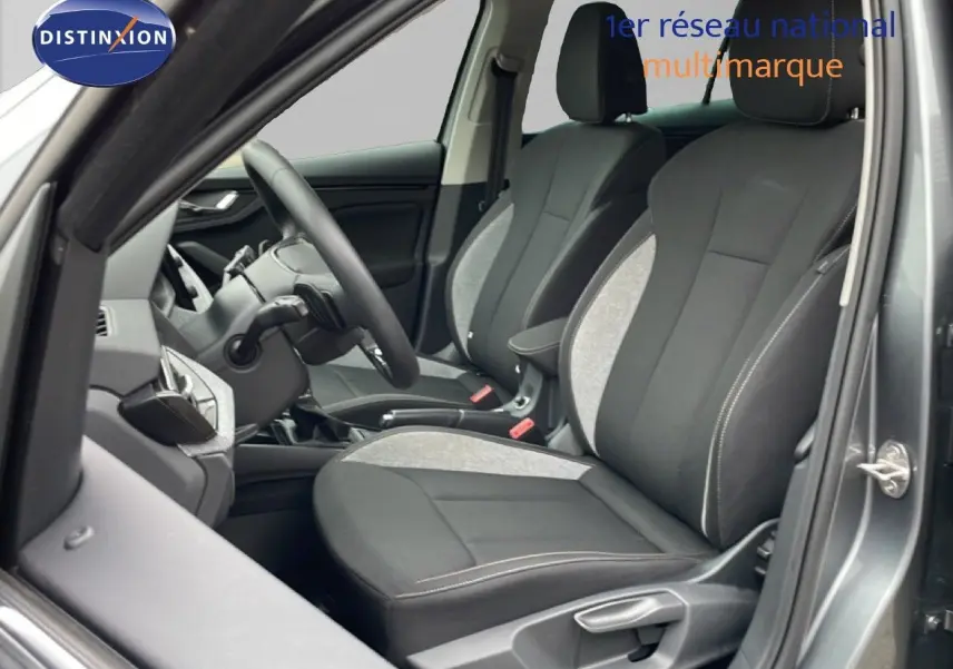 Vue intérieure côté conducteur du Skoda Kamiq 2025 gris graphite, sièges tissu noir et gris avec coutures contrastées.