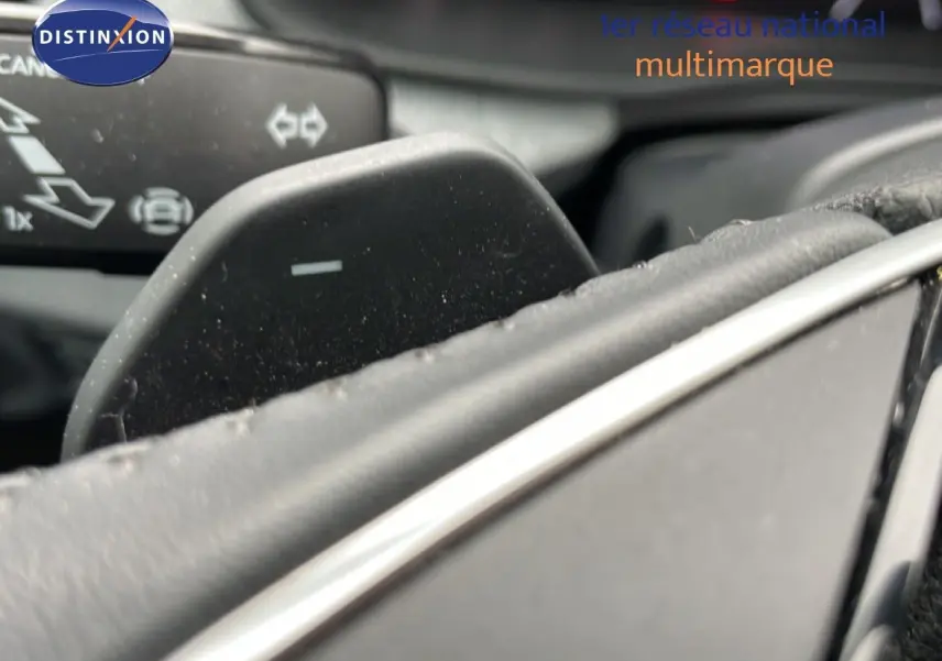 Gros plan sur la palette de changement de vitesse du volant d’un Skoda Kamiq gris graphite, intérieur noir.