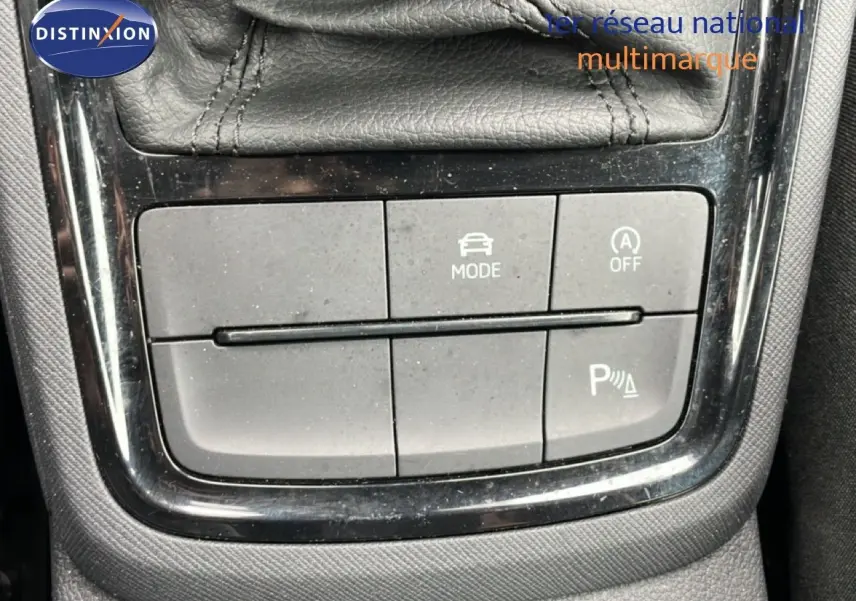 Gros plan sur les boutons de commande du mode de conduite et assistance au stationnement du Skoda Kamiq gris graphite.