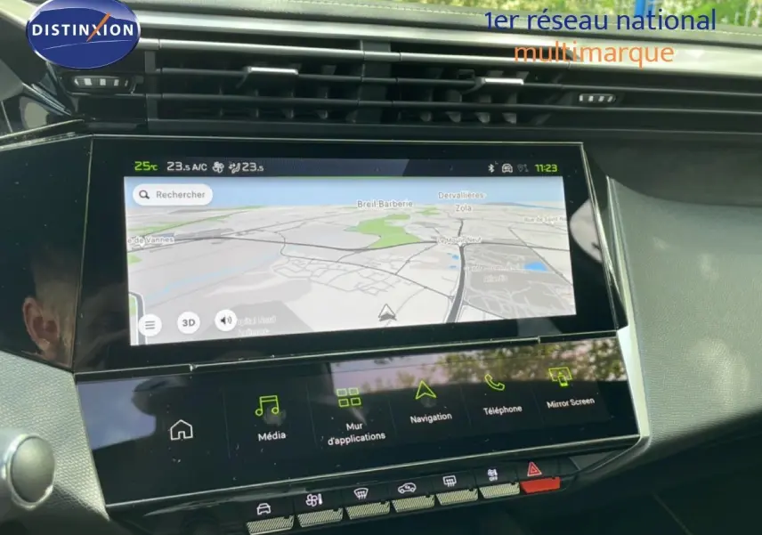 Vue intérieure du tableau de bord de la Peugeot 308 gris Artense, avec écran tactile de navigation allumé.