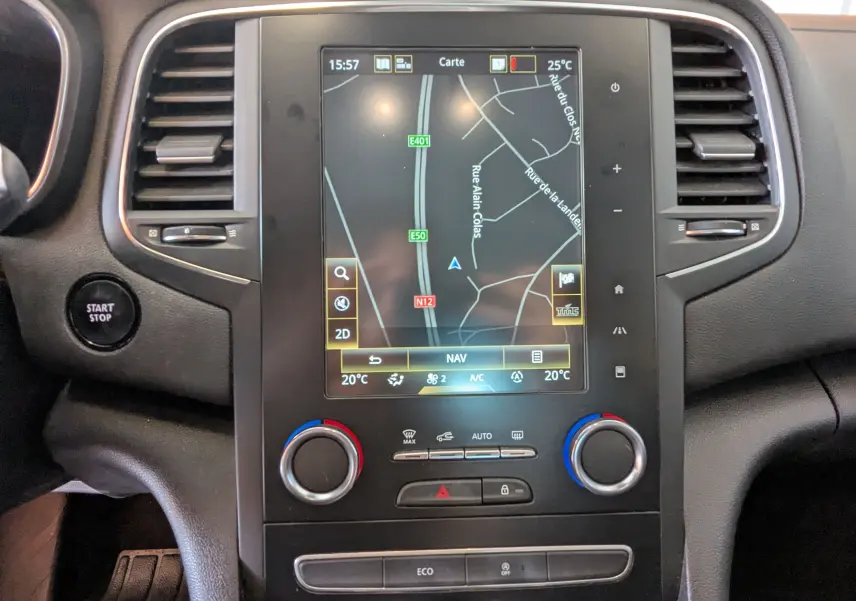 Vue rapprochée du tableau de bord de la Renault Mégane IV gris, avec écran tactile affichant la navigation GPS.
