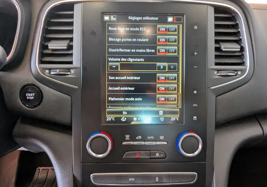 Vue rapprochée de la console centrale grise de la Renault Mégane IV 1.5 BlueDCI avec écran tactile affichant les réglages utilisateur.