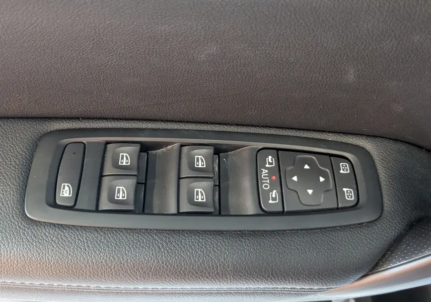 Panneau de commandes des vitres et rétroviseurs sur la porte côté gauche d'une Renault Mégane IV gris, intérieur noir.