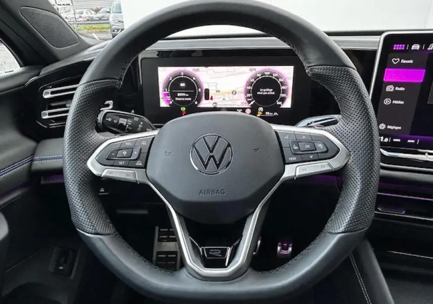Volant cuir multifonction du Volkswagen Tiguan R-Line 2024 avec tableau de bord numérique et écran tactile visible.