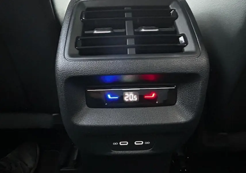 Détail de la console centrale arrière du Volkswagen Tiguan gris clair 2024 avec commandes clim et ports USB-C visibles.